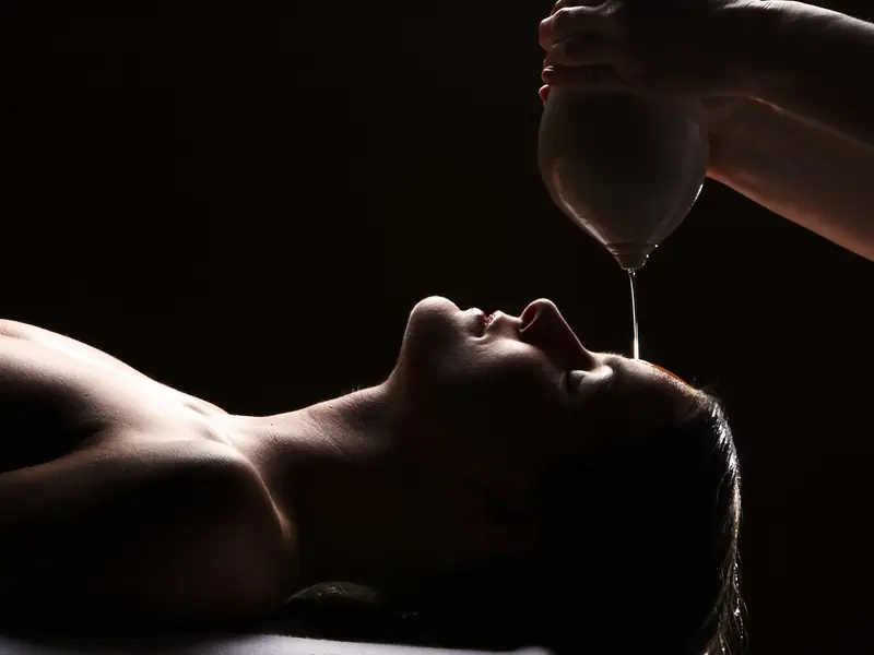 Warm oil poured in a steady stream on the forehead during Shirodhara