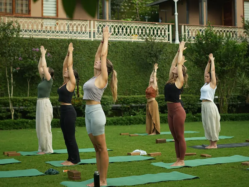A group practising yoga outdoors in the early morning